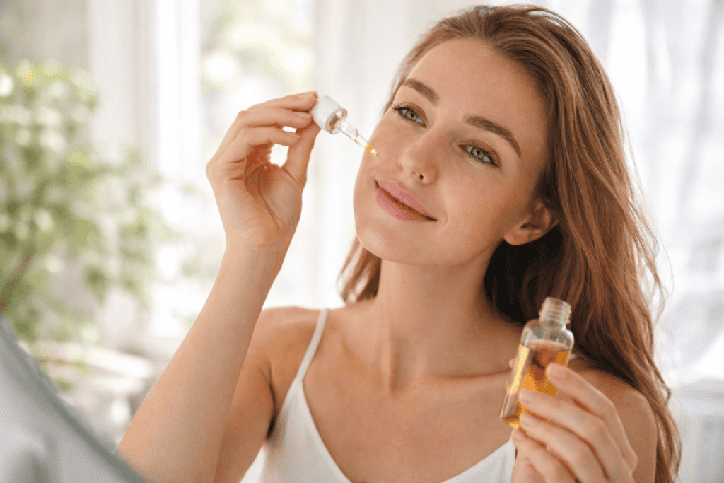 Woman applying natural skincare serum in morning routine for acne-prone skin