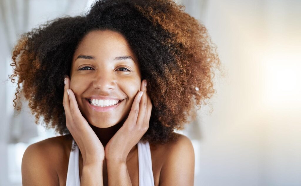 Woman with clear healthy skin comparing natural skincare oils for acne-prone skin
