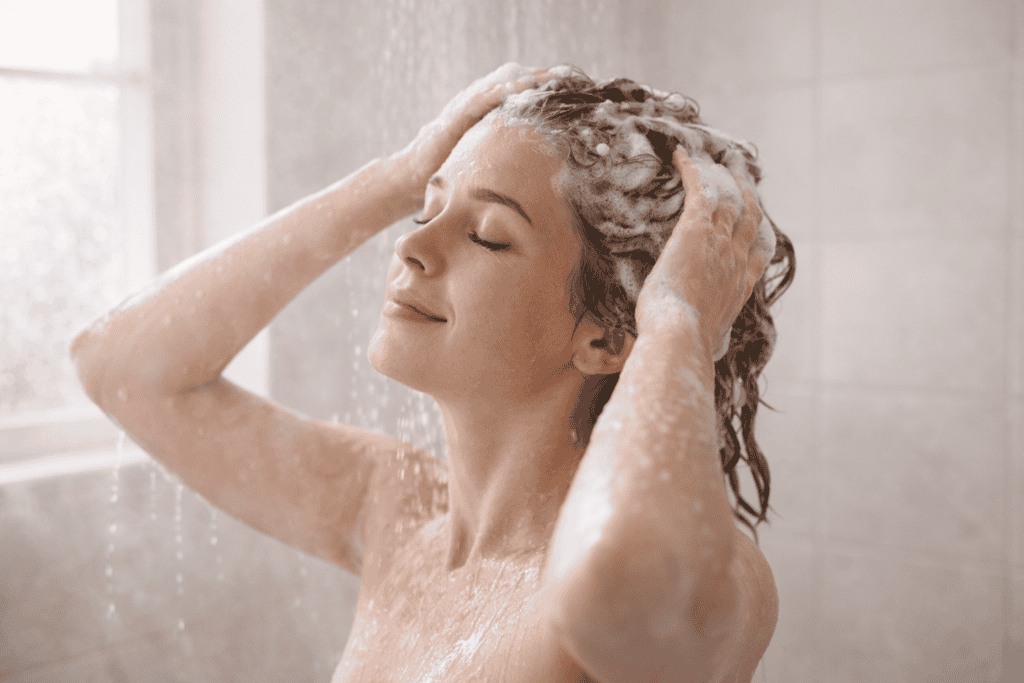 How to use a shampoo bar. Woman washing hair in shower during natural shampoo bar transition period