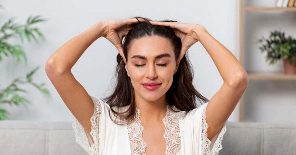 Woman performing Shiro Abhyanga scalp massage as part of Ayurvedic hair care routine